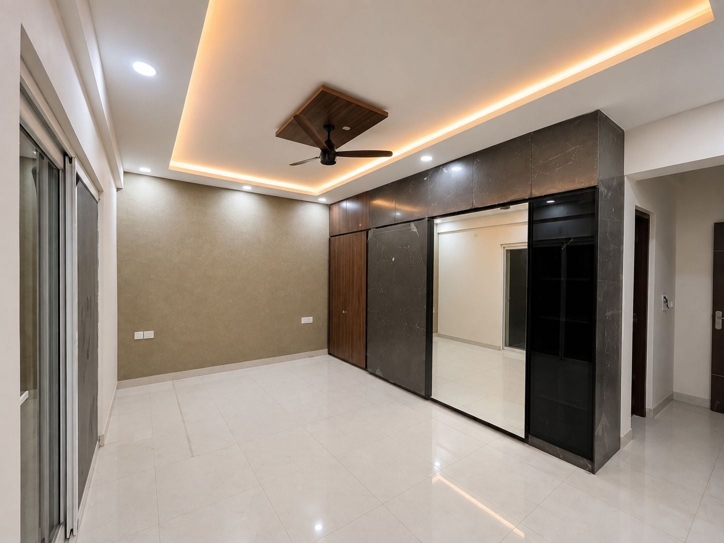 Room with a marble-clad, mirrored wardrobe wall